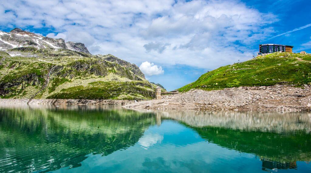 Grün blauer Bergsee und weiße Wolken